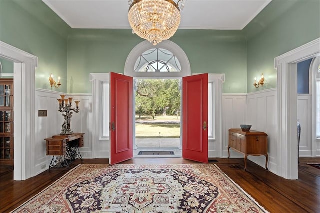 foyer entrance with an inviting chandelier and dark wood-type flooring