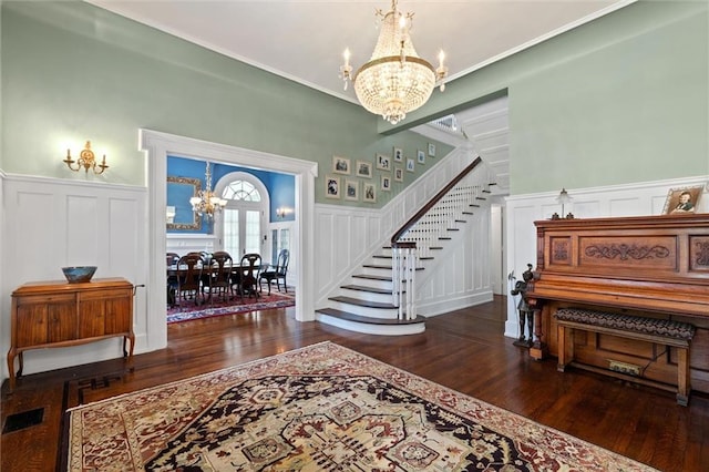 foyer entrance with dark hardwood / wood-style floors and an inviting chandelier