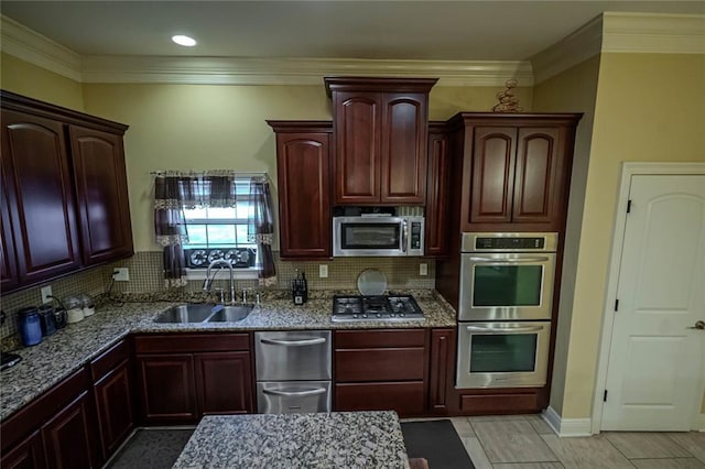 kitchen with appliances with stainless steel finishes, sink, stone countertops, and decorative backsplash