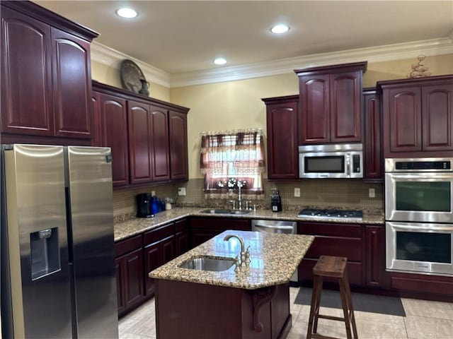 kitchen featuring sink, backsplash, appliances with stainless steel finishes, and light stone counters