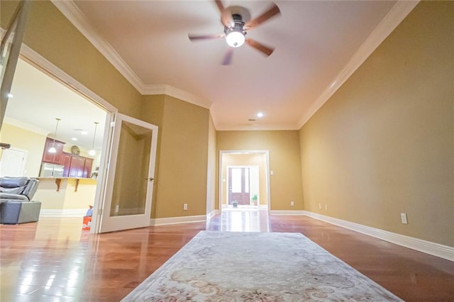 interior space with ceiling fan, wood-type flooring, ornamental molding, and refrigerator