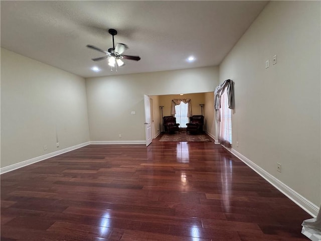 unfurnished living room with ceiling fan and dark wood-type flooring