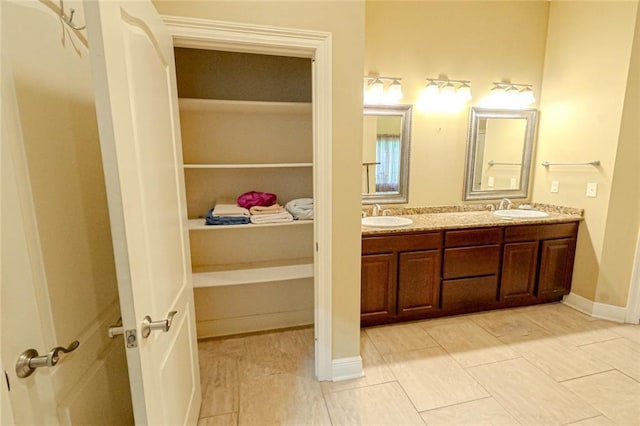 bathroom with tile patterned floors and dual vanity