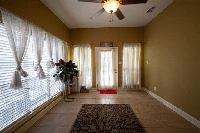 doorway to outside featuring ceiling fan, plenty of natural light, and light tile patterned flooring