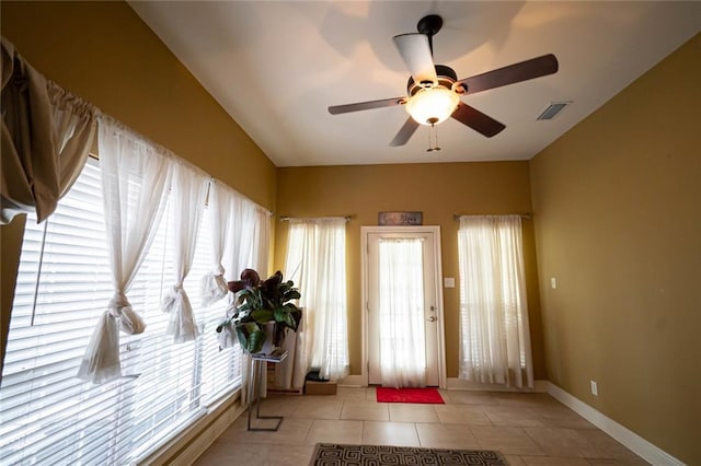 doorway to outside featuring light tile patterned floors, ceiling fan, and a healthy amount of sunlight