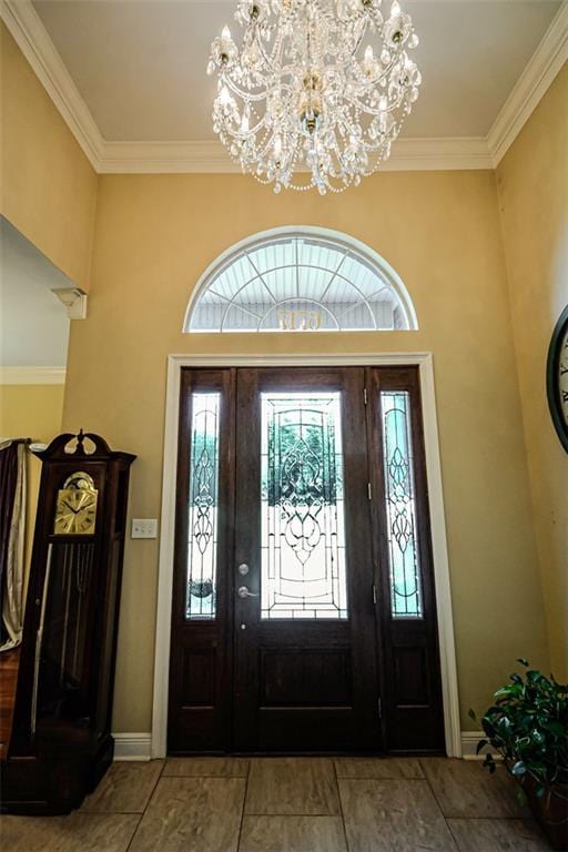 entryway featuring light tile patterned floors, crown molding, and an inviting chandelier