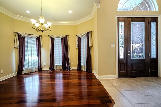 tiled foyer entrance with an inviting chandelier and crown molding