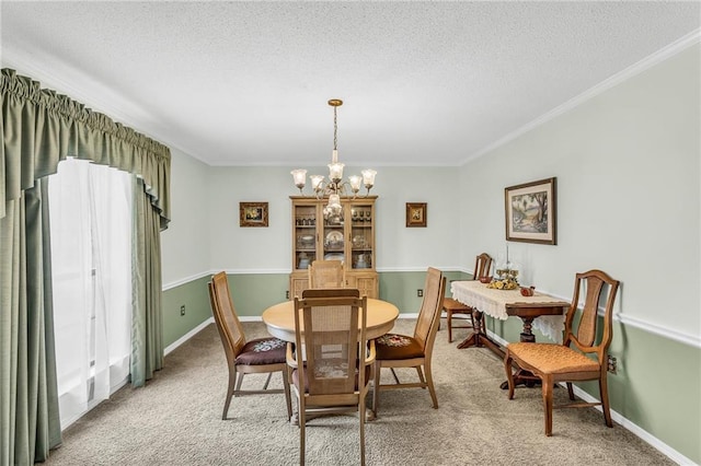 dining room featuring light colored carpet, ornamental molding, a textured ceiling, a chandelier, and baseboards