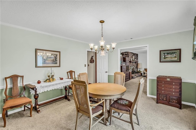 dining room with crown molding, a notable chandelier, a fireplace, light carpet, and baseboards