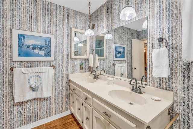 bathroom featuring a sink and wallpapered walls