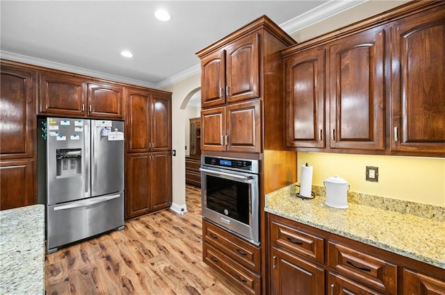 7180 Cannon Ball Cir, Bay Minette, AL 36507 - kitchen with crown molding, light stone countertops, light wood-style floors, arched walkways, and stainless steel appliances