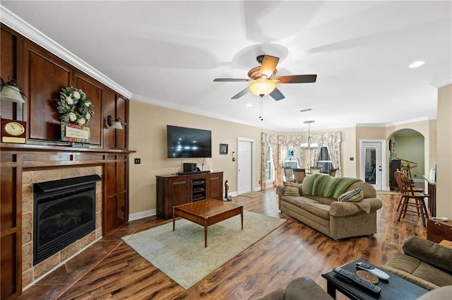 7180 Cannon Ball Cir, Bay Minette, AL 36507 - living area featuring a tiled fireplace, arched walkways, crown molding, and ceiling fan