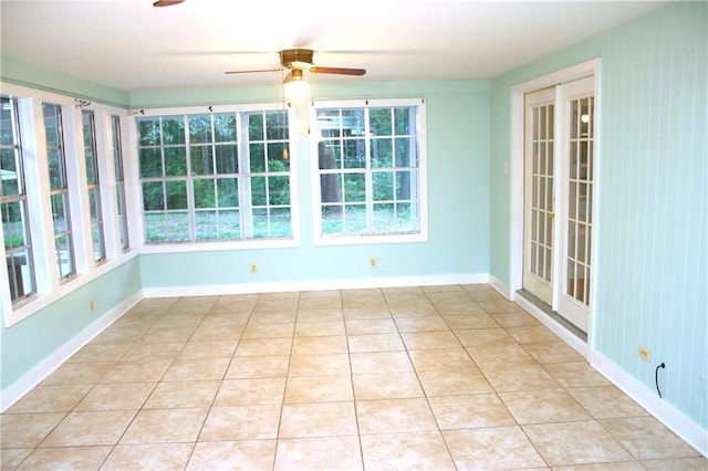 unfurnished sunroom featuring ceiling fan and a wealth of natural light