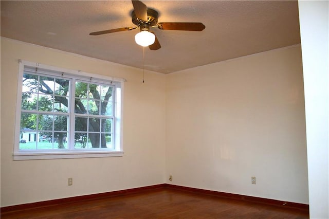 unfurnished room featuring plenty of natural light, dark wood-type flooring, and ceiling fan