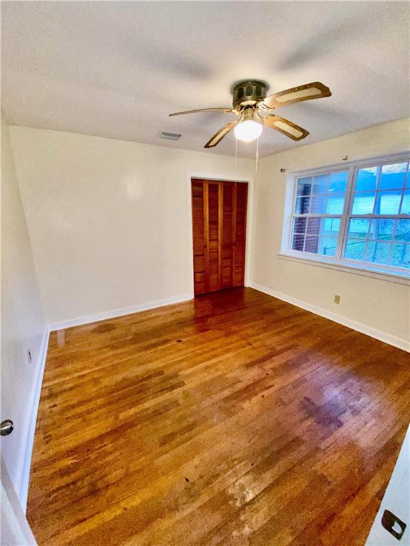 empty room featuring ceiling fan and dark hardwood / wood-style floors