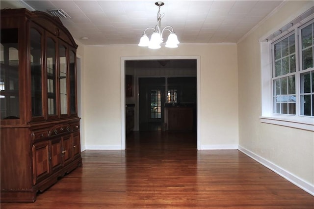 interior space featuring dark hardwood / wood-style flooring, a notable chandelier, and crown molding