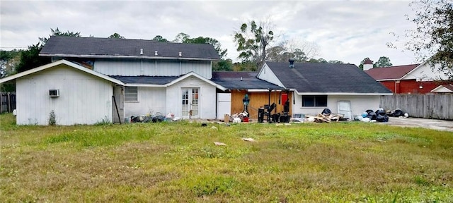 rear view of property featuring a lawn