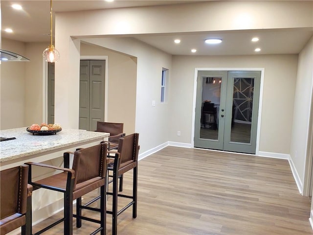 dining space with light hardwood / wood-style floors and french doors