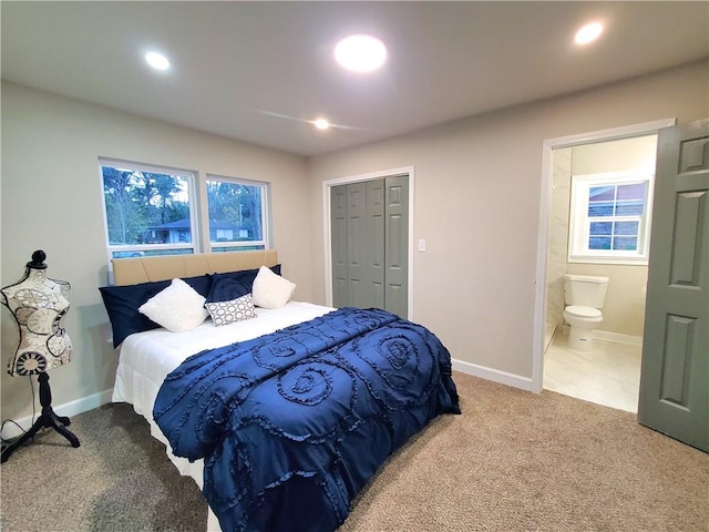 bedroom with ensuite bathroom, a closet, and carpet