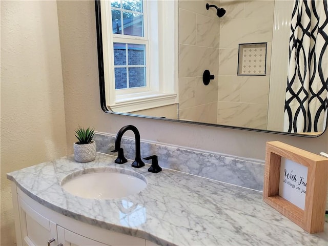 bathroom featuring vanity and tiled shower