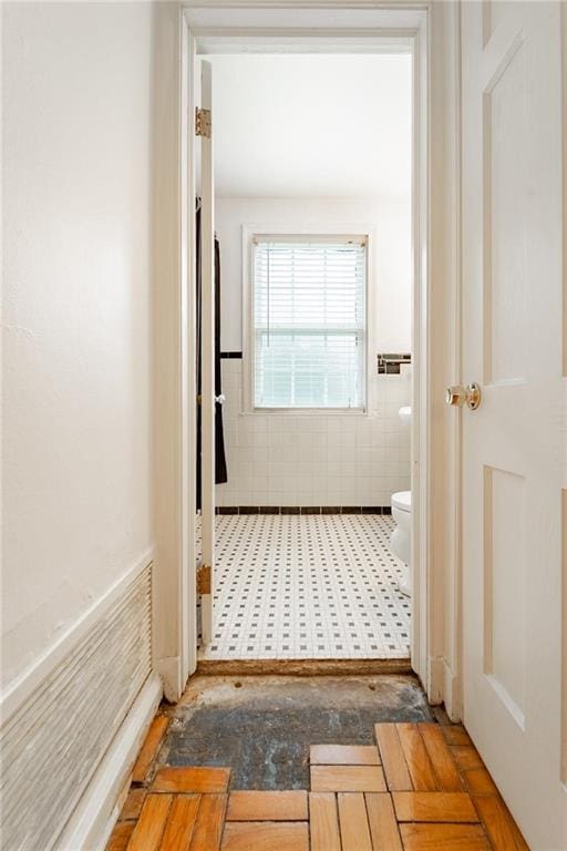 hall featuring tile walls