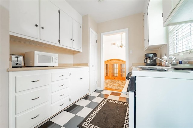 kitchen with white cabinetry, a chandelier, and white appliances