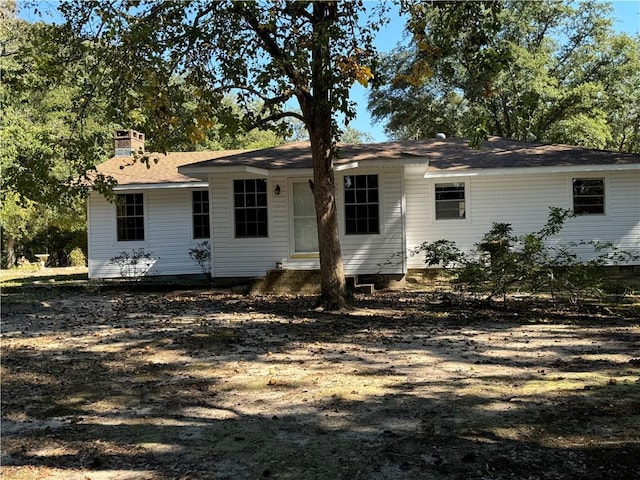 back of property with entry steps and a chimney