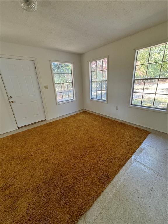 unfurnished room featuring light floors and a textured ceiling