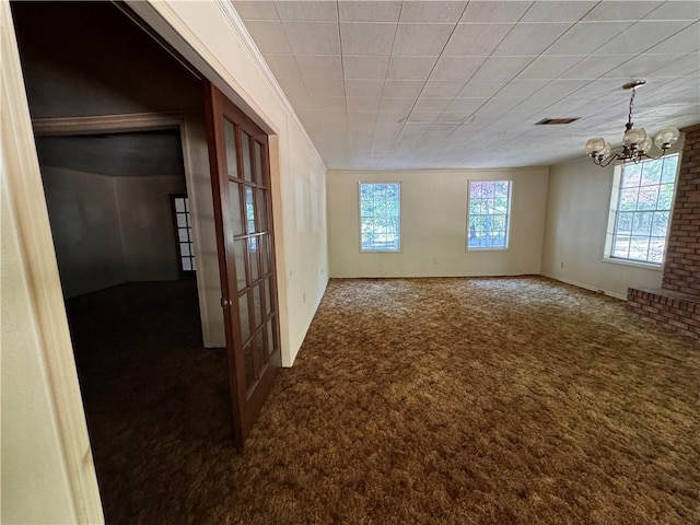 unfurnished room with ornamental molding, carpet, visible vents, and a chandelier