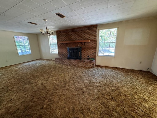 unfurnished living room featuring baseboards, visible vents, carpet floors, ornamental molding, and a chandelier