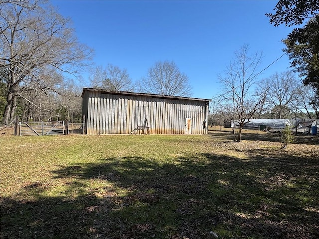 view of pole building featuring a yard and fence