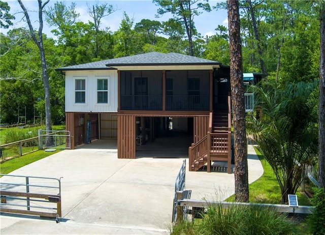 908 Longfellow Pl, Dauphin Island, AL 36528 - beach home with a sunroom, driveway, a carport, roof with shingles, and stairway