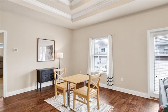 dining room featuring a raised ceiling, ornamental molding, and dark hardwood / wood-style floors