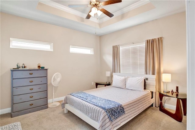 carpeted bedroom featuring ceiling fan, crown molding, and a tray ceiling