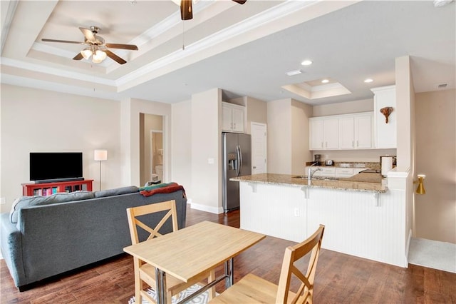 dining area with ornamental molding, dark hardwood / wood-style flooring, ceiling fan, a tray ceiling, and sink