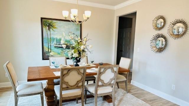 dining area featuring light hardwood / wood-style floors, an inviting chandelier, and crown molding