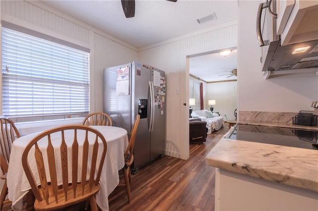 dining space featuring ceiling fan, dark wood-type flooring, and ornamental molding