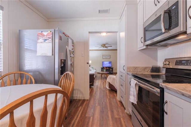 kitchen with ceiling fan, white cabinets, dark hardwood / wood-style floors, and appliances with stainless steel finishes