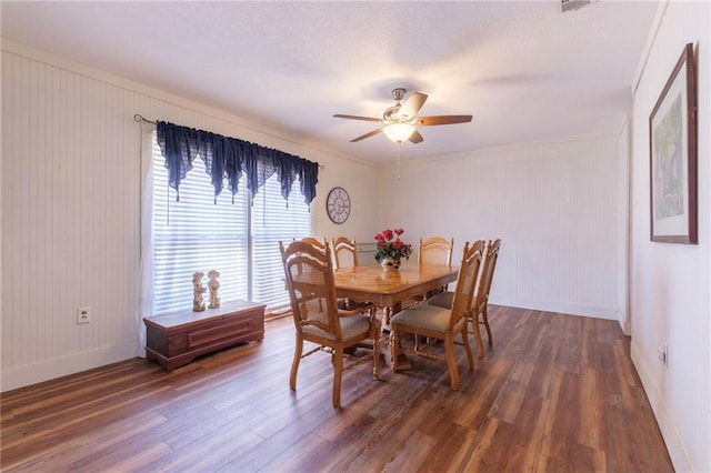 dining space with crown molding, ceiling fan, and dark wood-type flooring