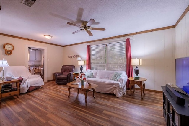 living room featuring a textured ceiling, dark hardwood / wood-style floors, ceiling fan, and ornamental molding