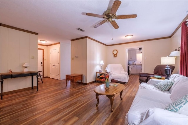 living room with ceiling fan, wood-type flooring, and crown molding