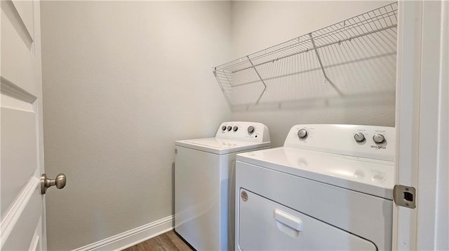 clothes washing area featuring washing machine and dryer and dark hardwood / wood-style floors