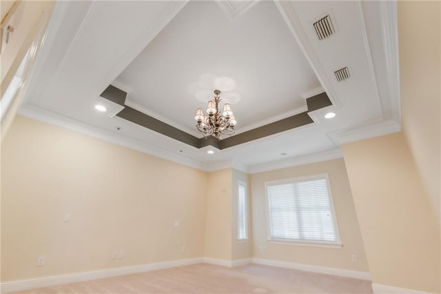 empty room with a chandelier, a raised ceiling, and crown molding