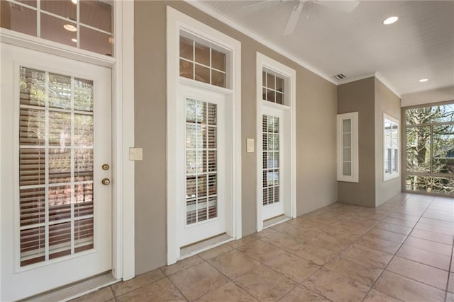 entryway with ceiling fan, crown molding, and light tile flooring