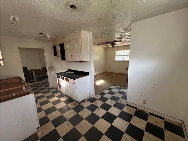 kitchen with white cabinets and a textured ceiling