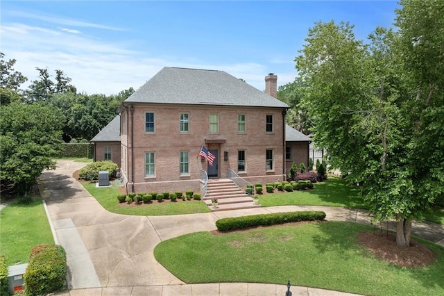 4008 Mcgregor Oaks, Mobile, AL 36608 - view of front of house with a front yard, driveway, a chimney, and brick siding