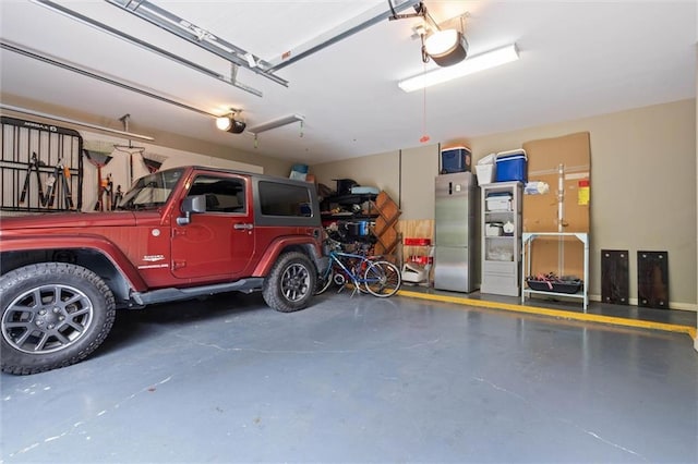 4008 Mcgregor Oaks, Mobile, AL 36608 - garage with a garage door opener and freestanding refrigerator