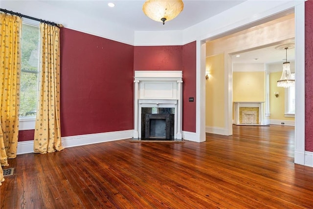 251 Georgia Ave S, Mobile, AL 36604 - unfurnished living room with hardwood / wood-style flooring, a wealth of natural light, a notable chandelier, and a fireplace