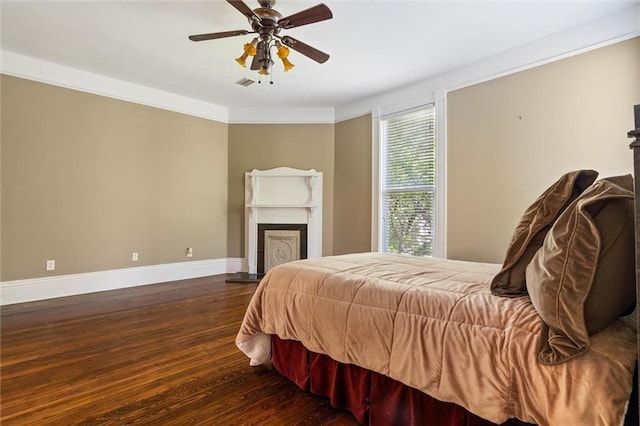 251 Georgia Ave S, Mobile, AL 36604 - bedroom with a fireplace with raised hearth, wood finished floors, visible vents, baseboards, and ceiling fan