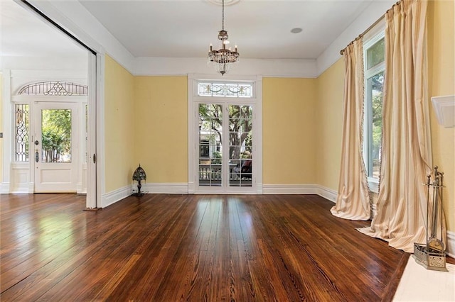 251 Georgia Ave S, Mobile, AL 36604 - unfurnished dining area featuring baseboards, a healthy amount of sunlight, a chandelier, and dark wood-style floors